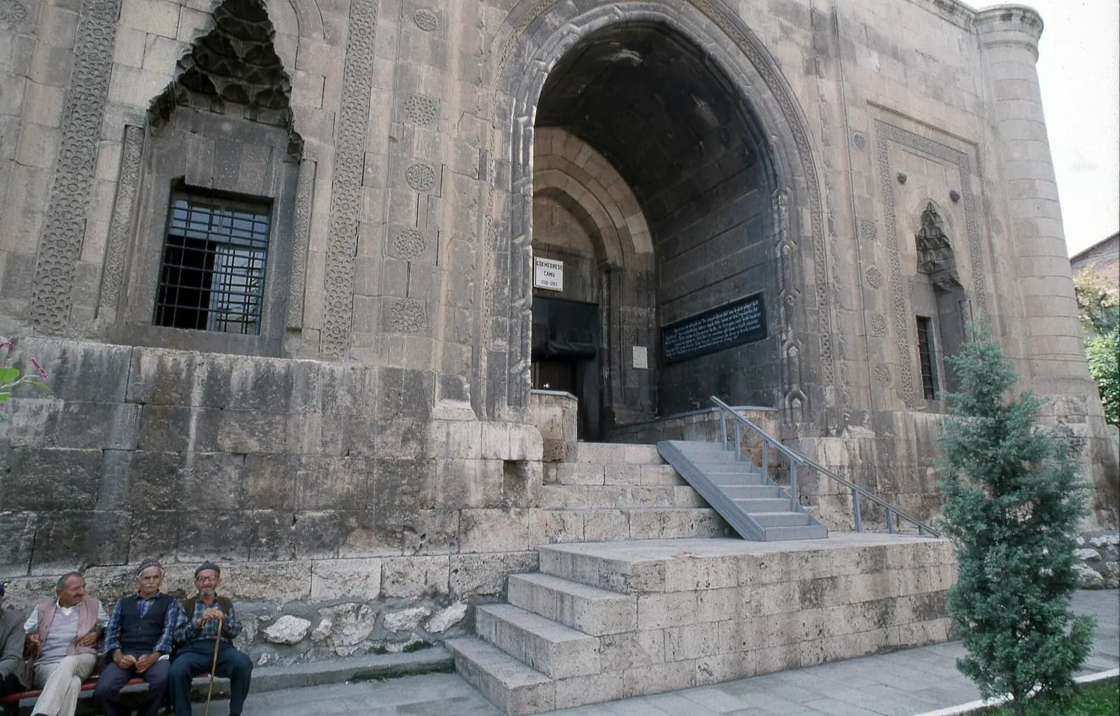 Gökmedrese Camii'nin sivri kemerli taç kapısı ve masif kesme taş cephesi
